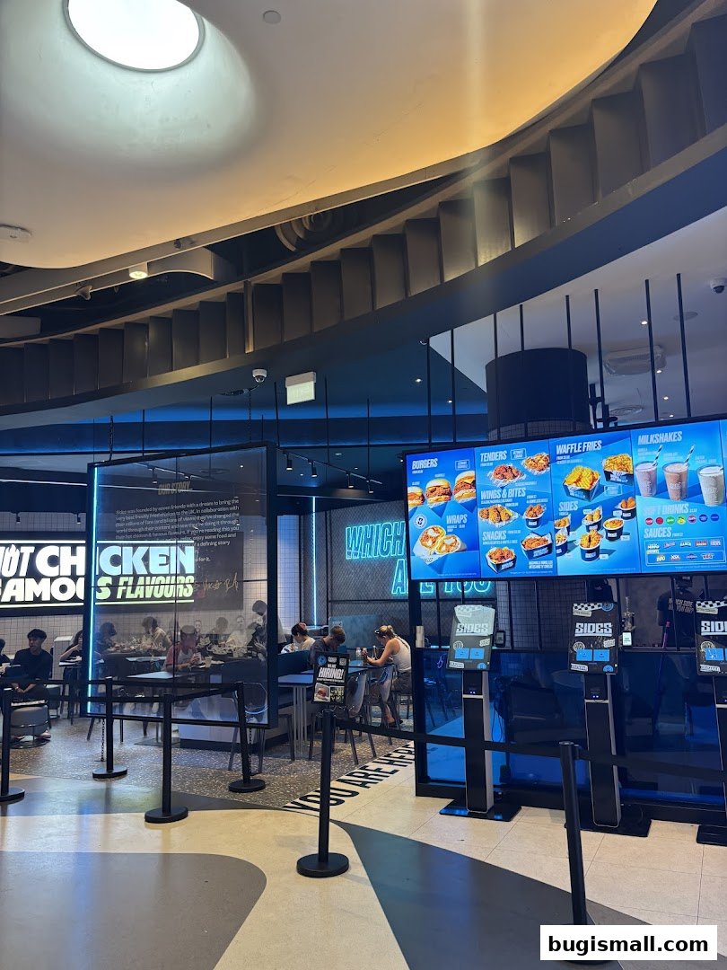 Interior of a modern fast-food restaurant with digital menus displaying food items and customers dining.