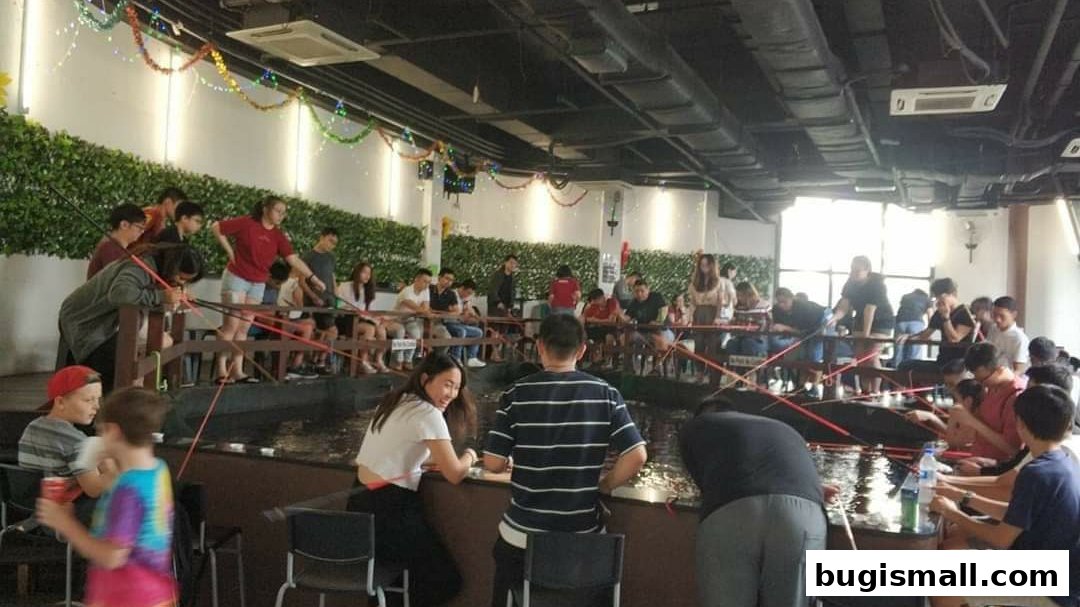 People fishing indoors at a venue with many fishing rods and a water area.