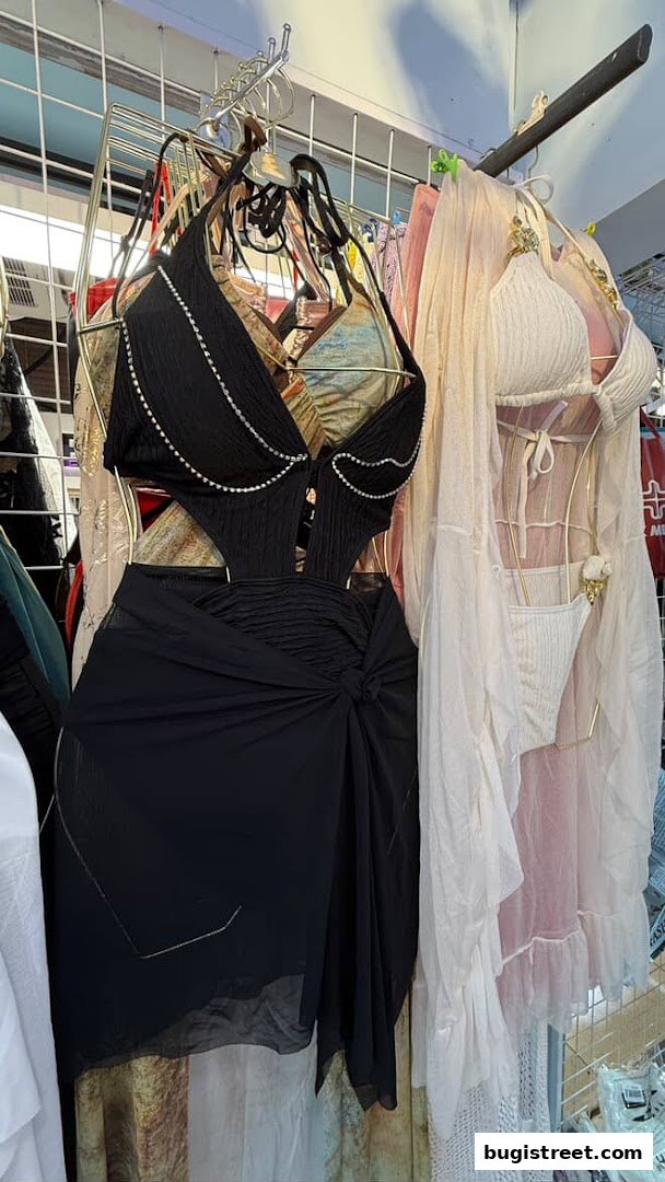 A black cutout swimsuit with beaded trim and a sheer black sarong.