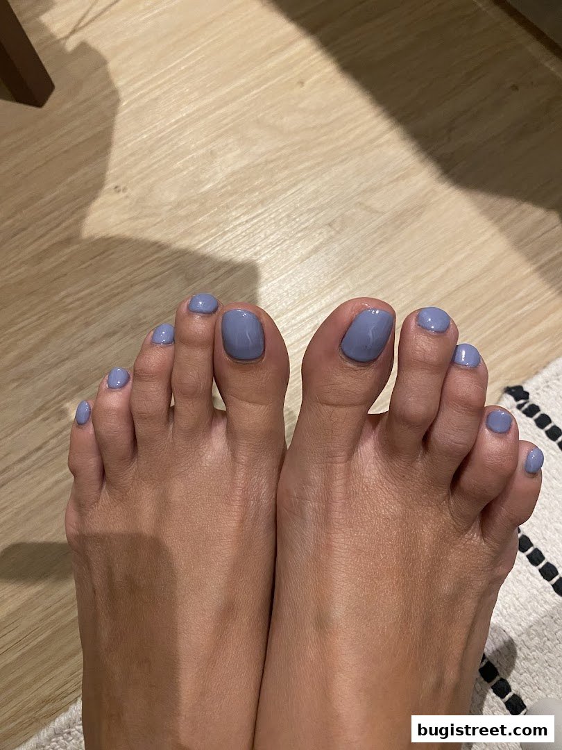 A close-up view of a person's feet with freshly painted lavender toenails.