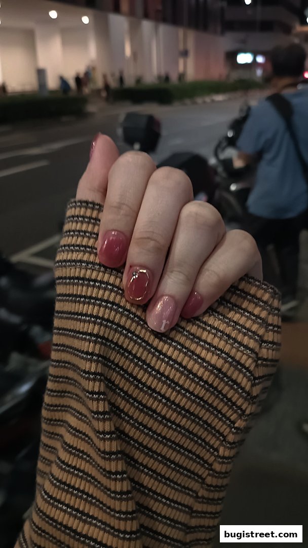 A close-up of a hand with beautifully manicured nails, showcasing a stylish design.