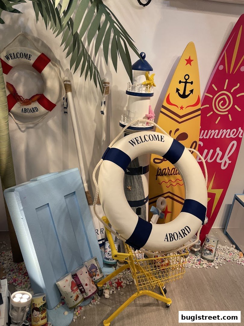 A beach-themed display with surfboards, a lighthouse, and life preservers.