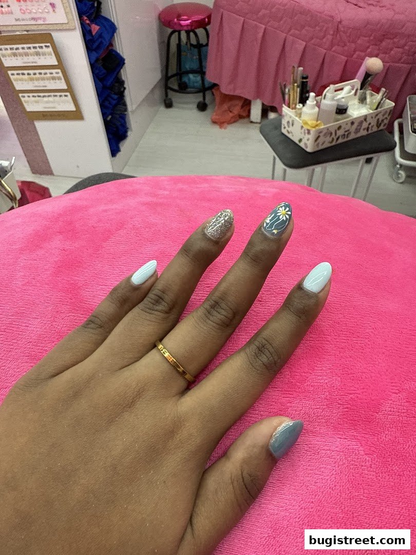 A hand with beautifully manicured nails, showcasing intricate nail art and polish.