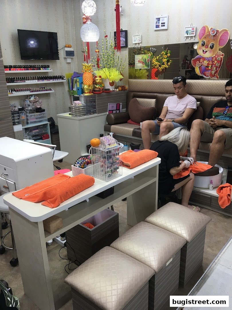 Nail spa interior with customers receiving pedicures and a display of nail polish.