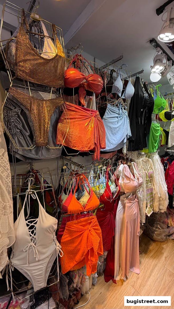 A vibrant display of stylish swimwear and cover-ups, featuring bikinis, one-pieces, and skirts.