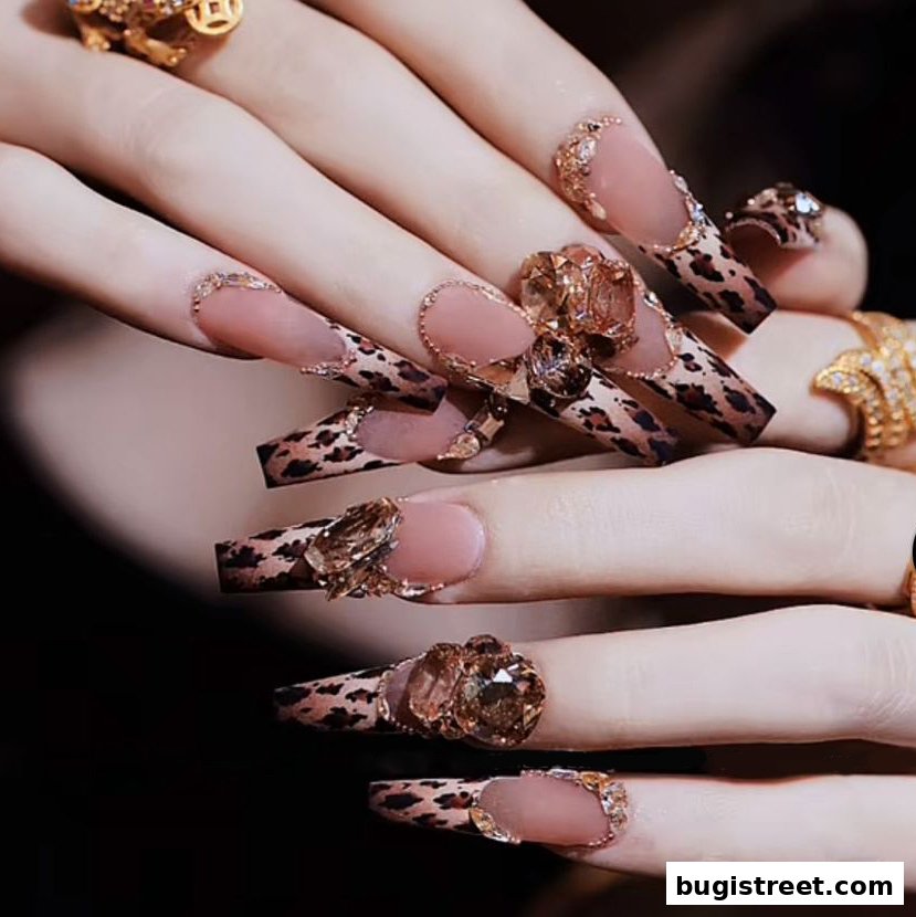 Close-up of hands with elaborate leopard print and jeweled acrylic nails.