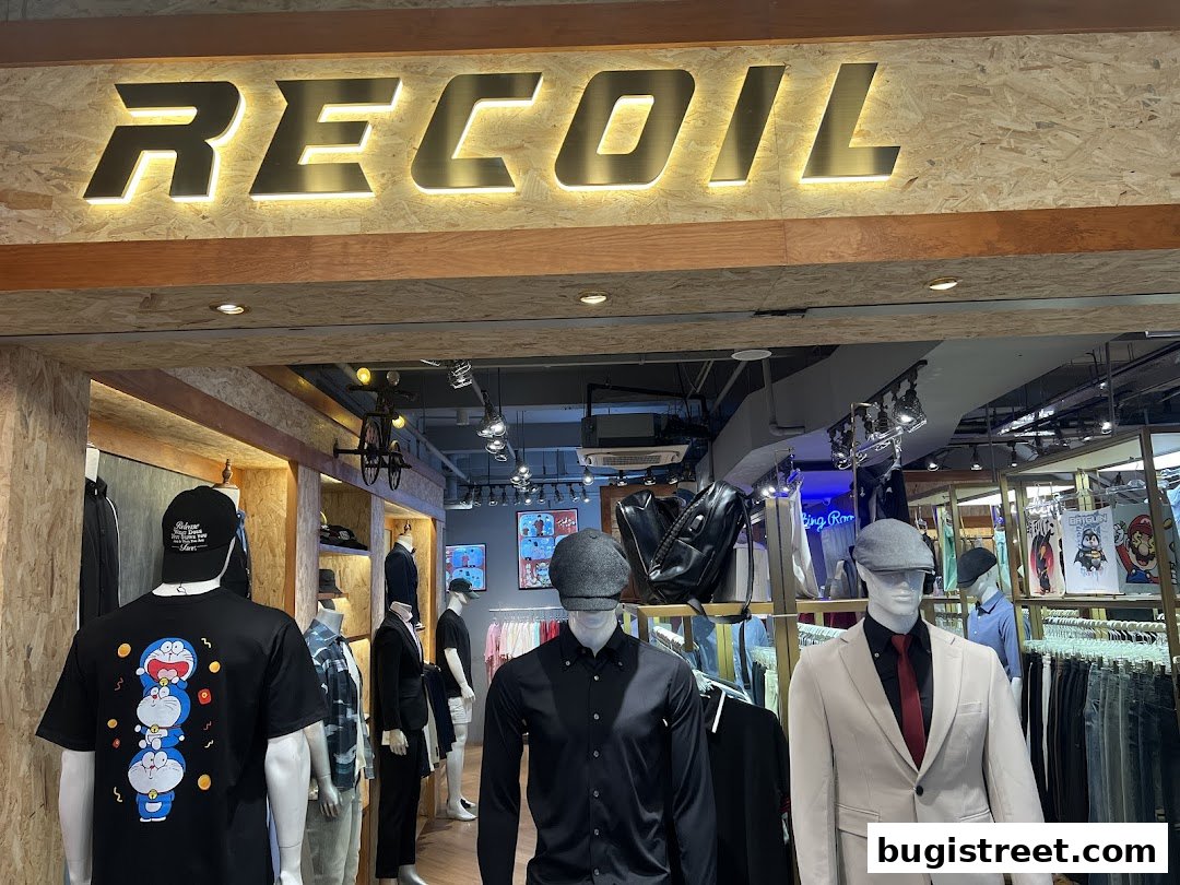 Shop front of Recoil with mannequins displaying clothing and the store's name above.