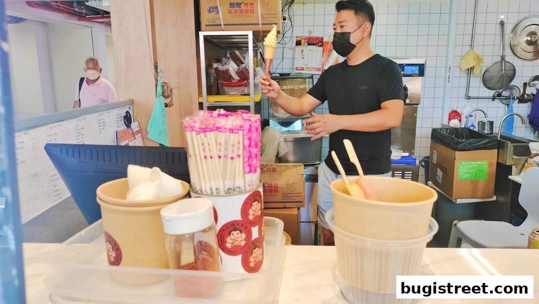A staff member at Chanko Oden prepares an ice cream cone for a customer.