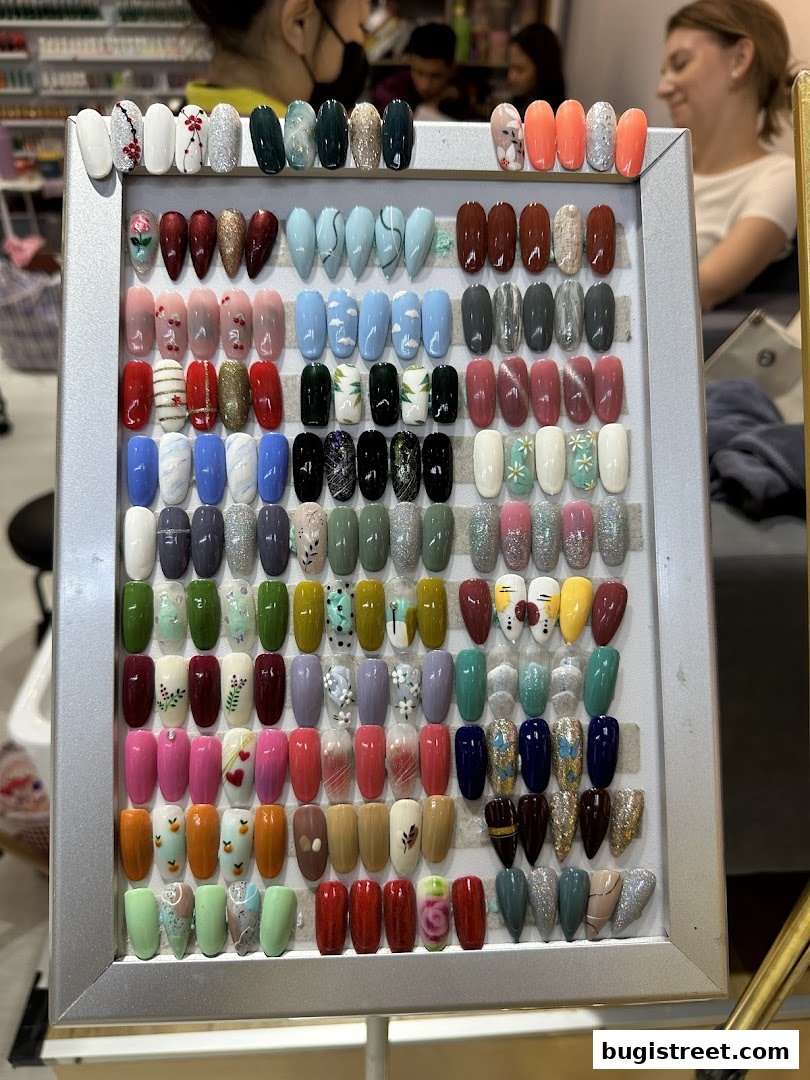 A display board showcasing a wide variety of artificial nails with different colors and designs.