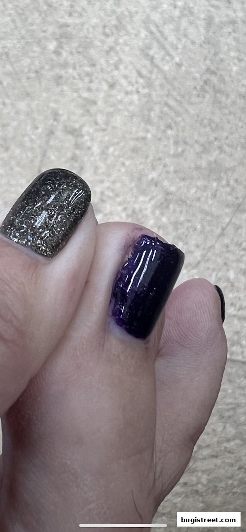 Close-up of toes with dark purple and glitter nail polish.