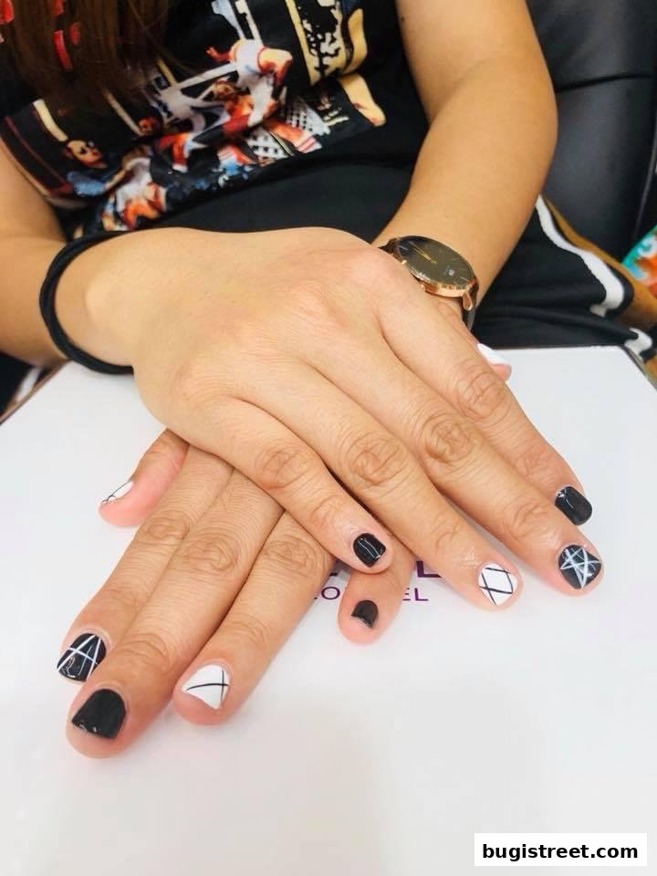 A close-up of hands with stylish black and white nail art.