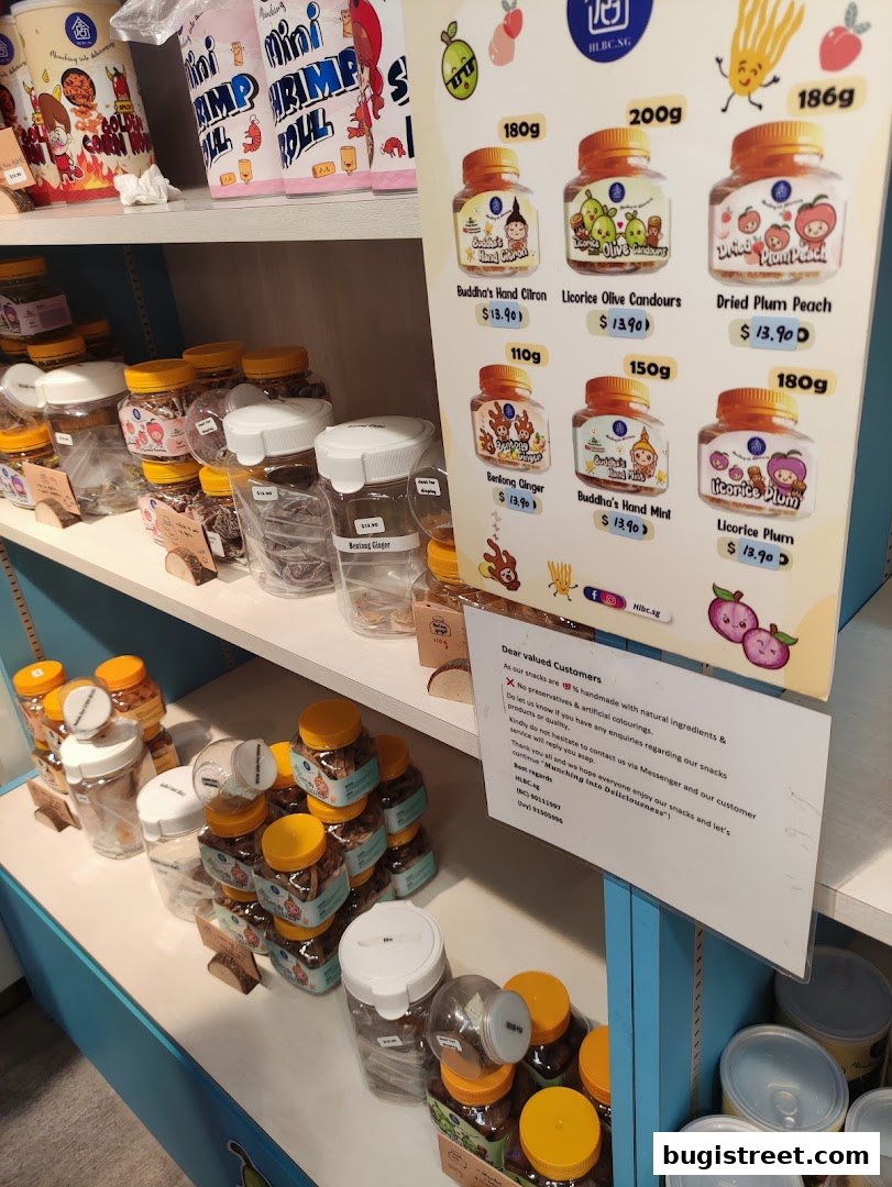 A display of various snacks in jars and packaging, with a price list on the right.