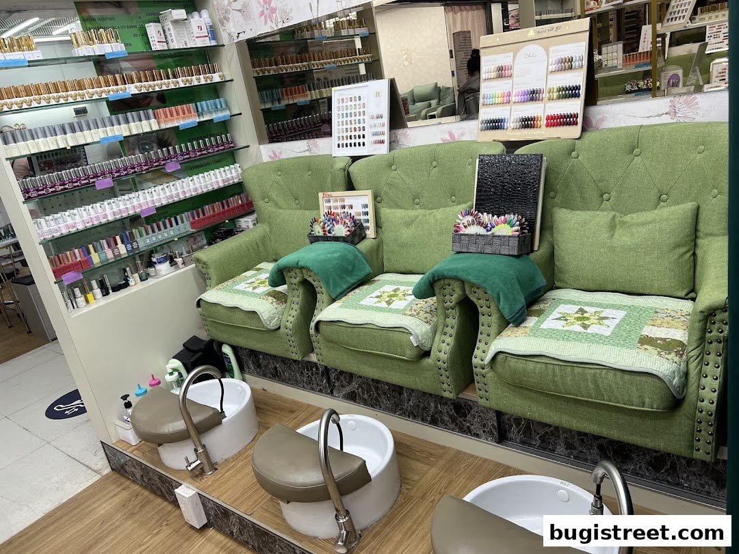 Interior of a nail salon with pedicure chairs, nail polish displays, and color swatch boards.