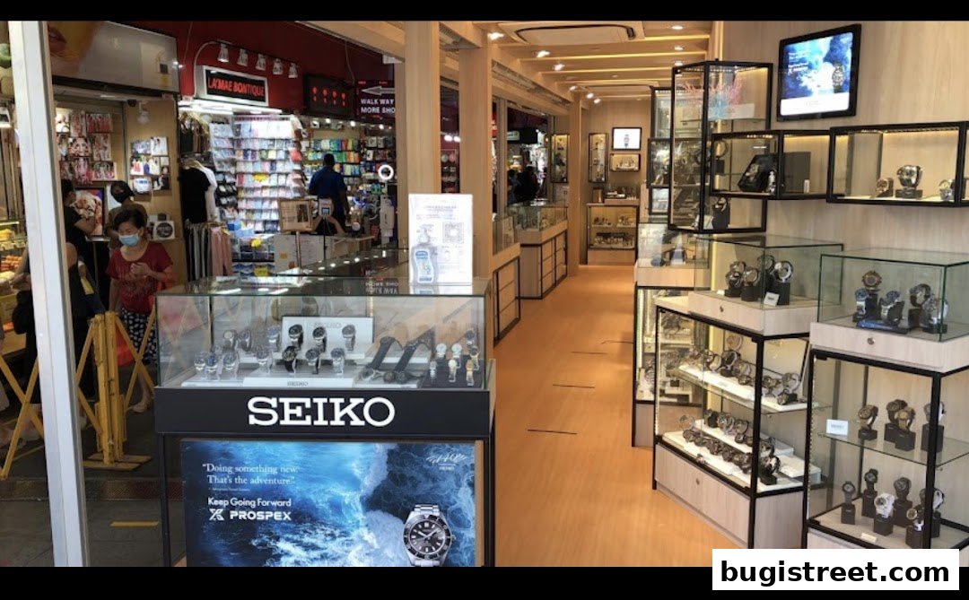 Interior view of a well-lit watch shop showcasing various timepieces in display cases.