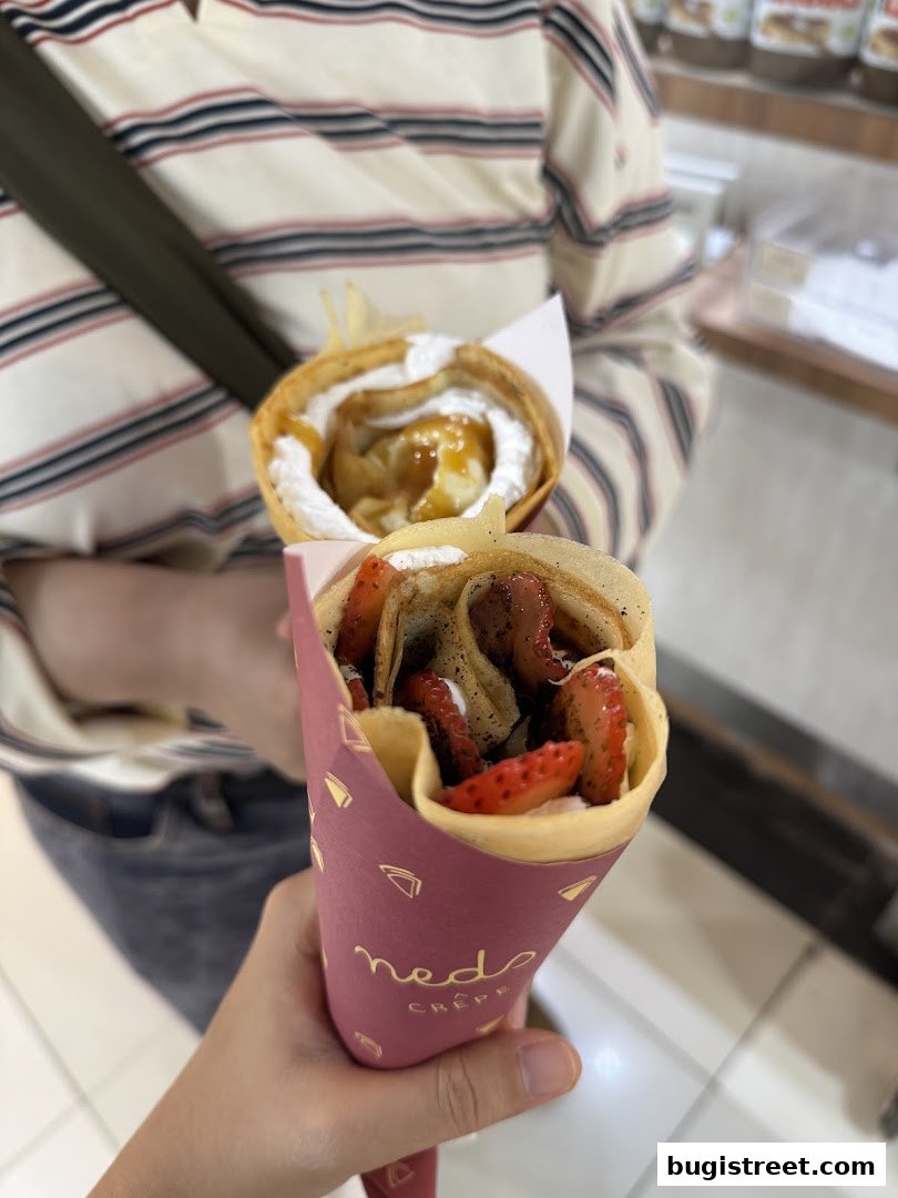 Two delicious crepes, one with strawberries and the other with caramel and cream.