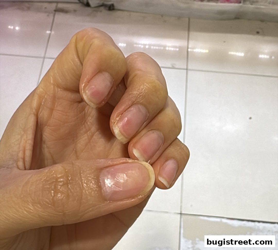 A close-up shot of a person's hand with natural, unpolished nails.