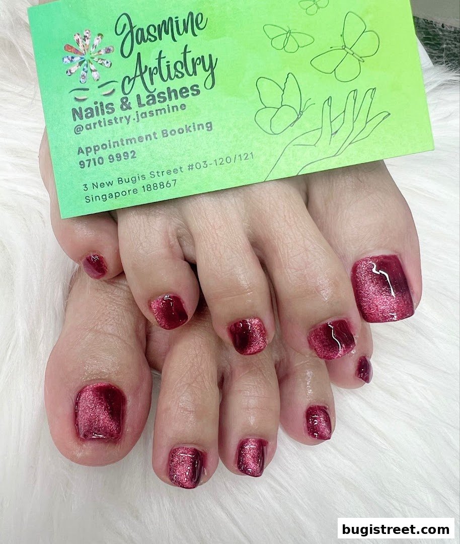 Close-up of feet with beautifully manicured toenails in a shimmering red polish.