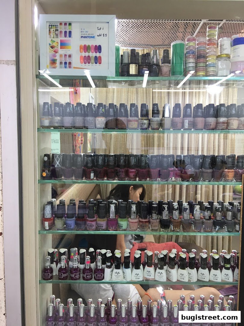 A display case filled with various shades of nail polish and nail art supplies.