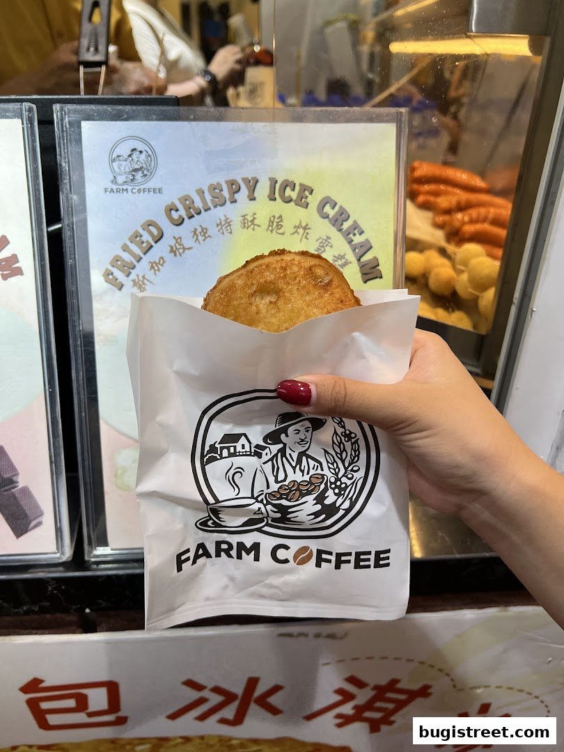 A hand holds a paper bag with the Farm Coffee logo, showing a fried crispy ice cream.