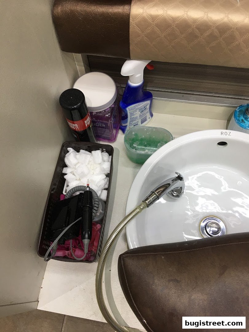 Nail spa station with tools, cleaning supplies, and a sink.