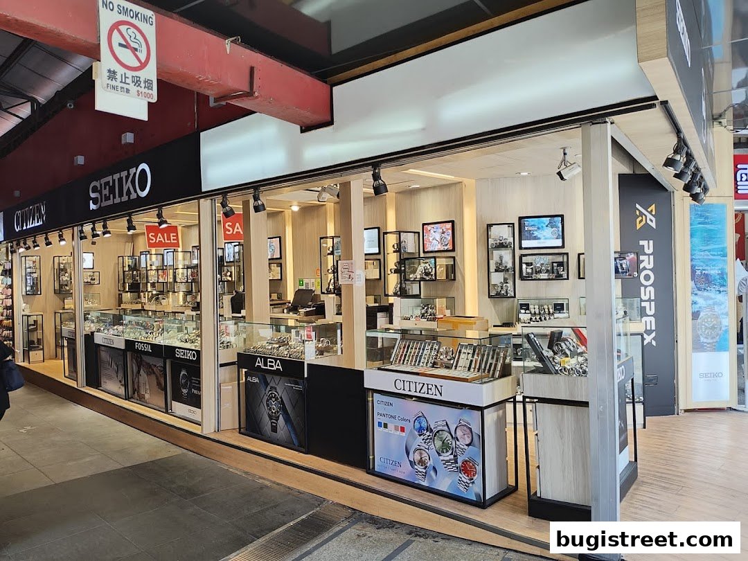 A well-lit watch shop displaying various brands like Seiko, Citizen, Fossil, and Alba.