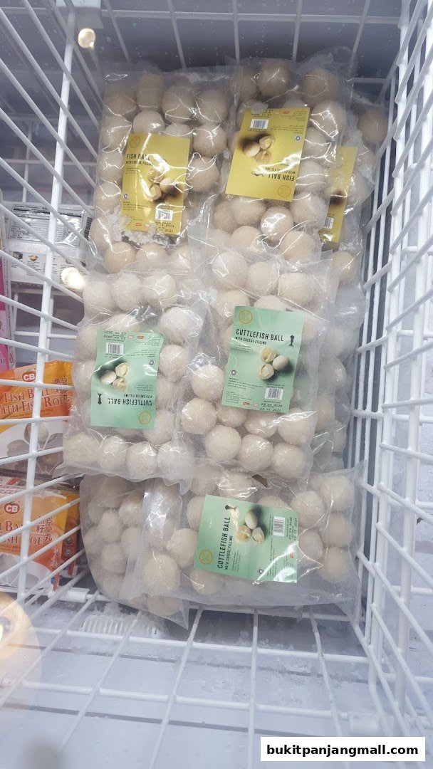 Frozen seafood balls, including cuttlefish balls with cheese filling, displayed in a freezer.