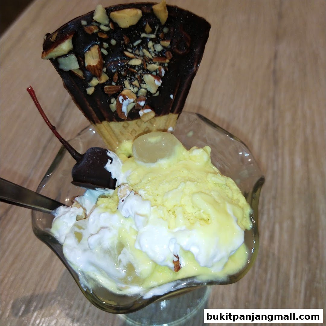 A delicious ice cream sundae with chocolate, nuts, and a cherry on top.