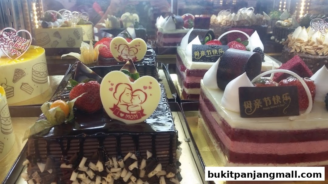 A display of beautifully decorated cakes, some with Mother's Day themes, in a bakery.