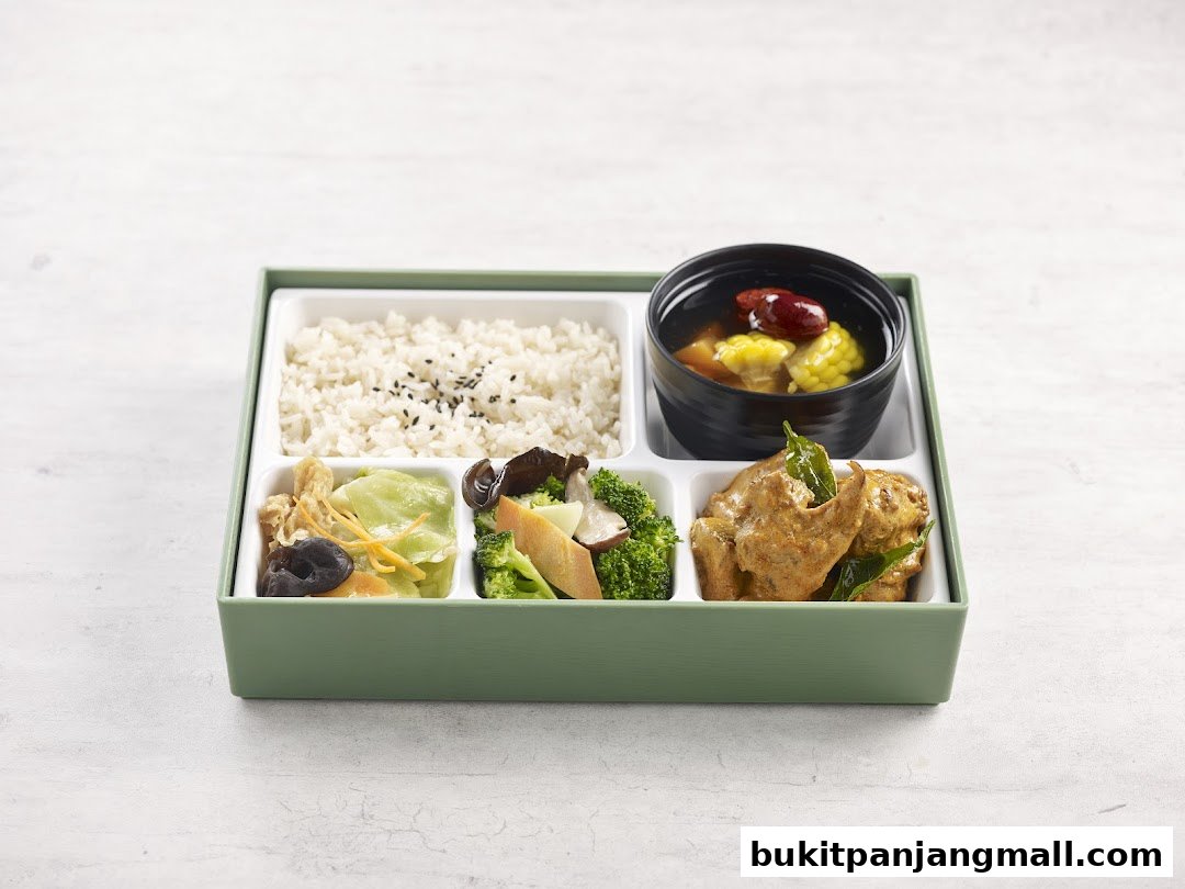 A bento box with rice, soup, vegetables, and a curry dish.