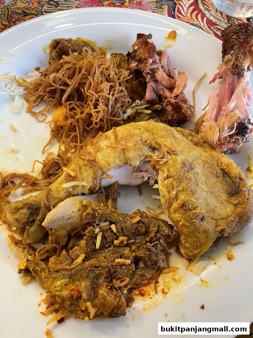 A plate of nasi lemak with chicken, beef rendang, and noodles.