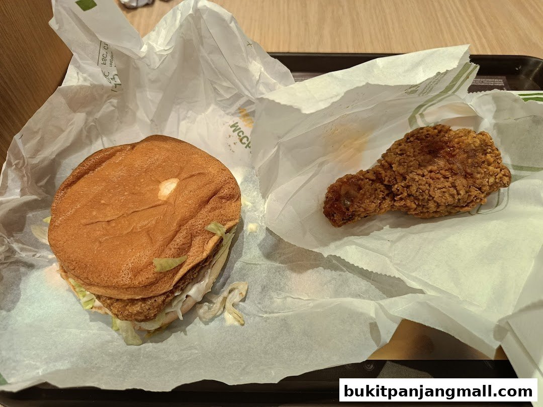 A close-up of a McDonald's burger and a piece of fried chicken on a tray.