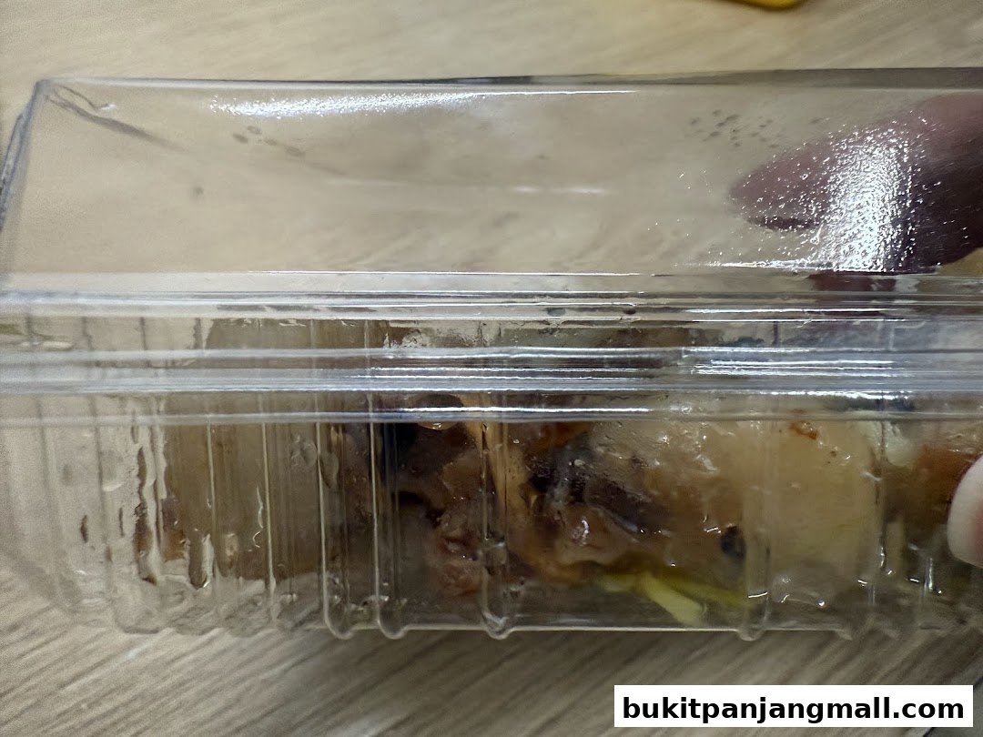 A close-up of Ang Ku Kueh in a clear plastic container.