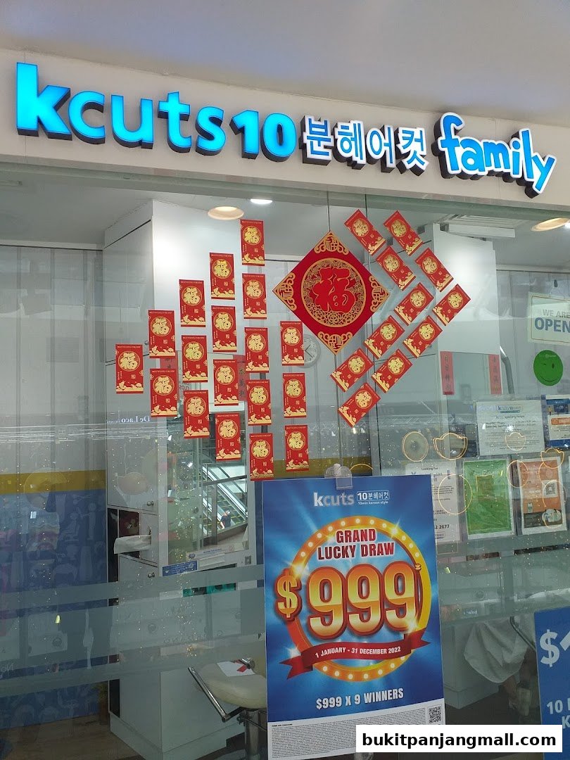 The storefront of Kcuts hair salon, decorated with Chinese New Year ornaments and a promotional poster.
