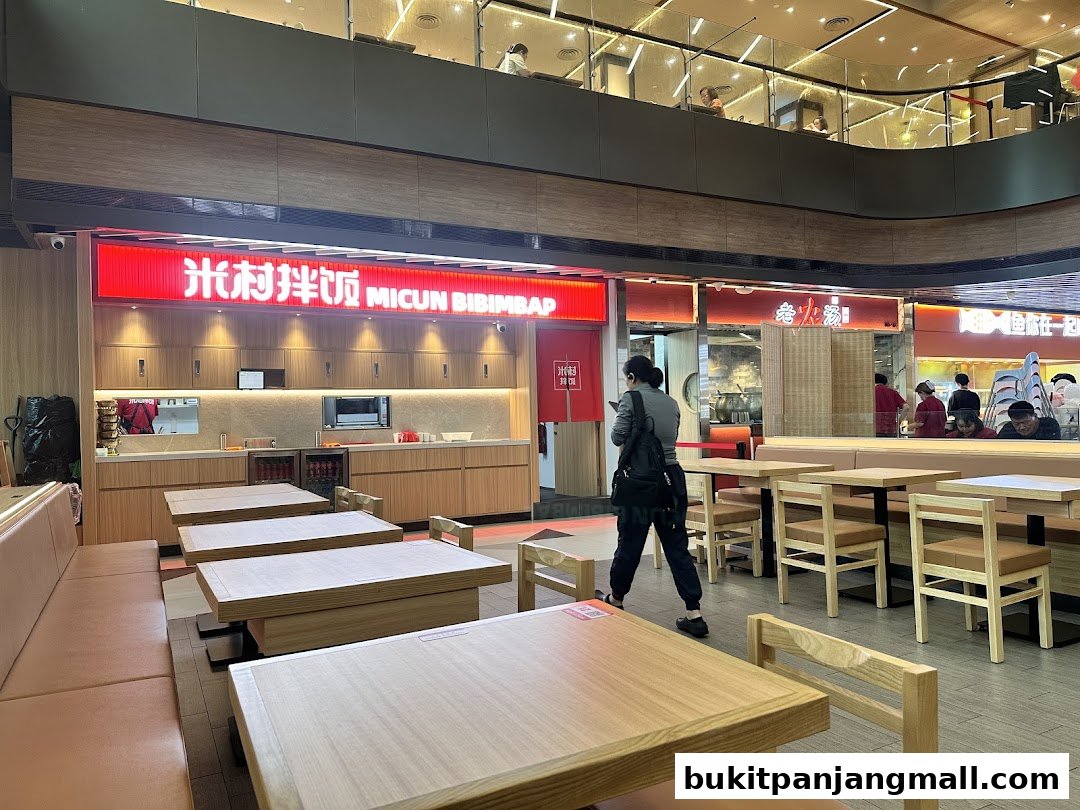 Interior view of Micun Bibimbap restaurant with tables and chairs, and the shop's illuminated sign.