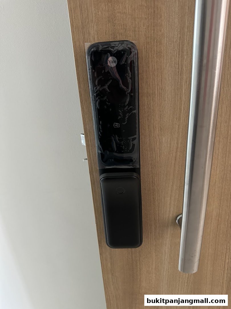 A close-up of a Yale smart lock installed on a wooden door.
