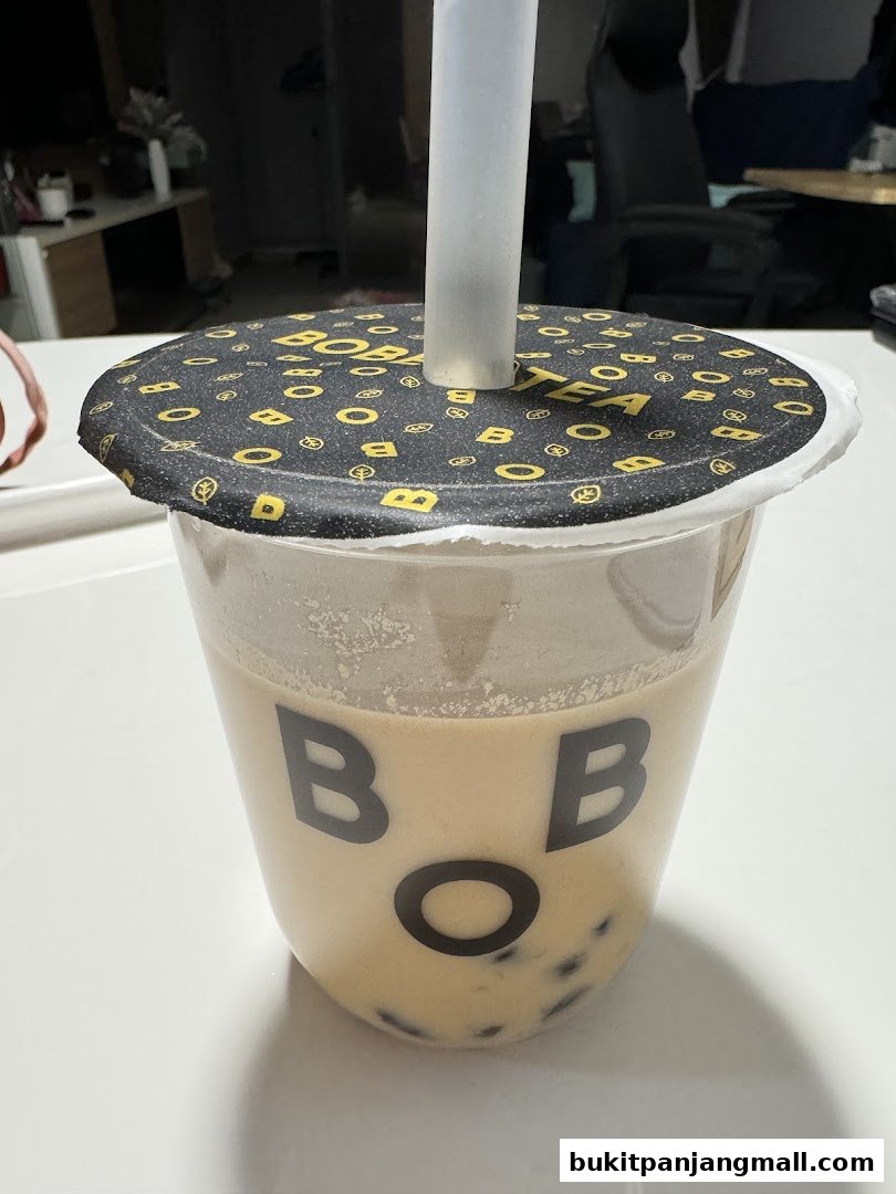 A close-up of a Bober Tea drink with tapioca pearls and a branded lid.
