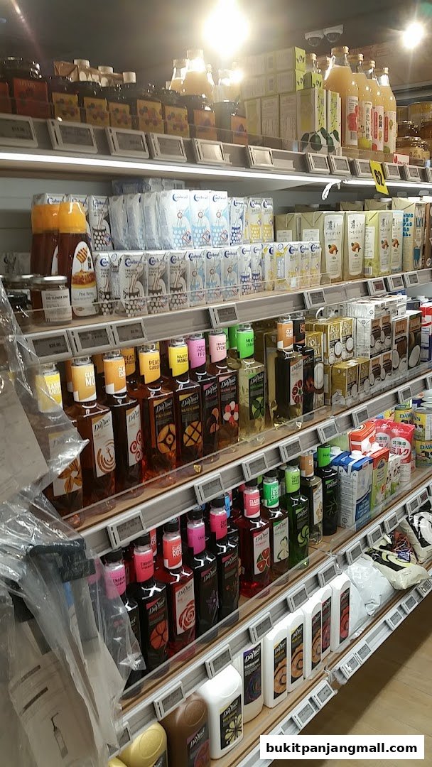 Shelves stocked with various beverages, syrups, and packaged goods in a retail store.