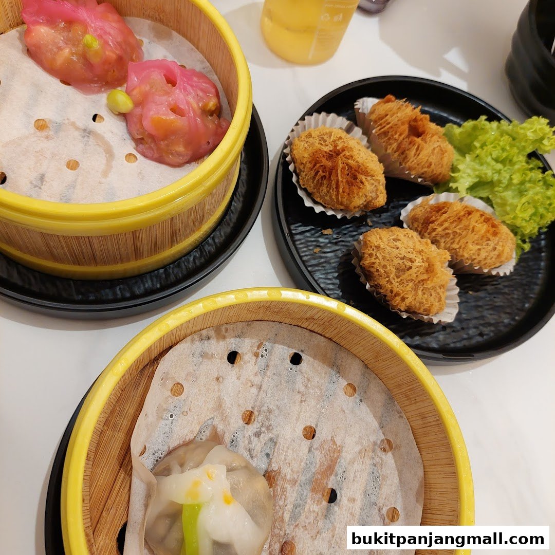 A close-up of various dim sum dishes served in bamboo steamers and on a black plate.