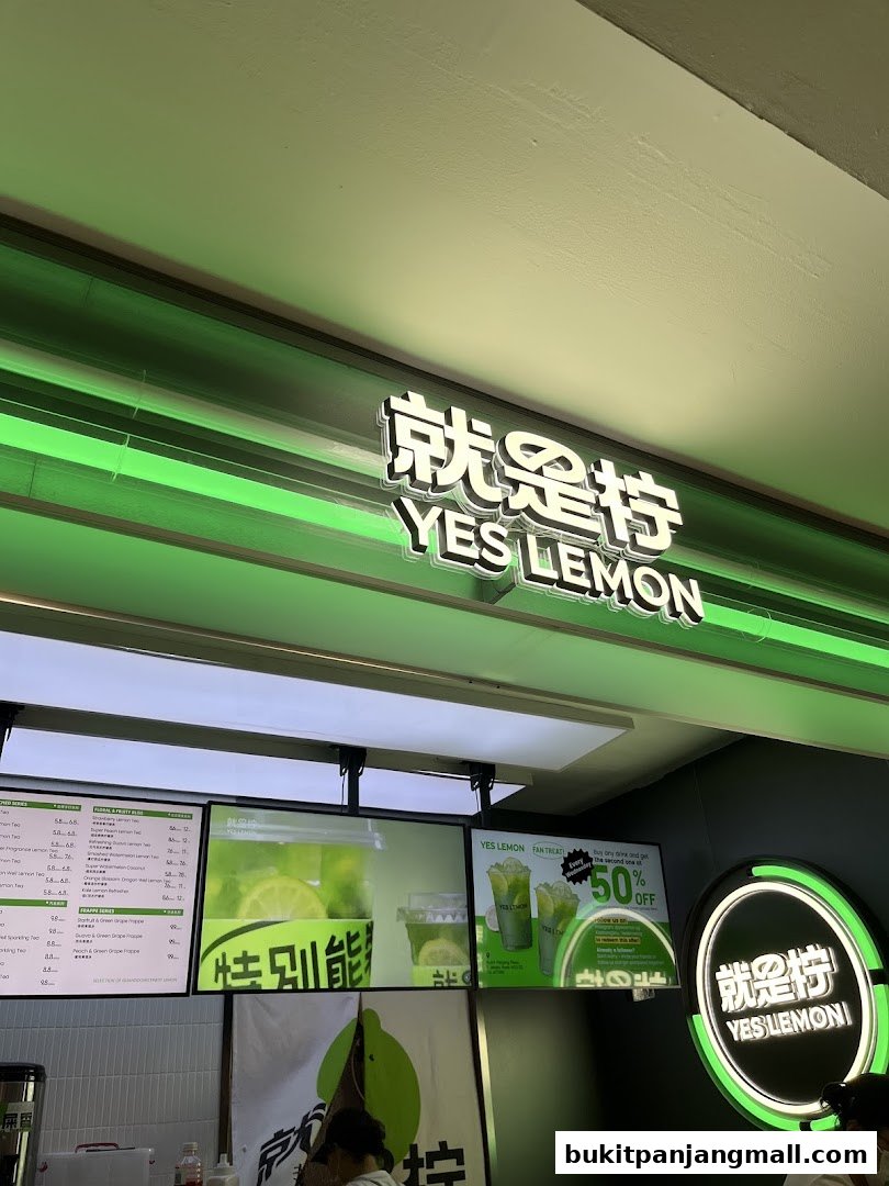 The storefront of YES LEMON, a beverage shop, with its illuminated sign and menu displays.