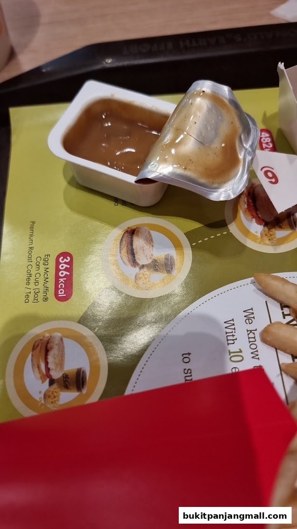 A close-up of McDonald's food items including a sauce packet and fries on a tray liner.