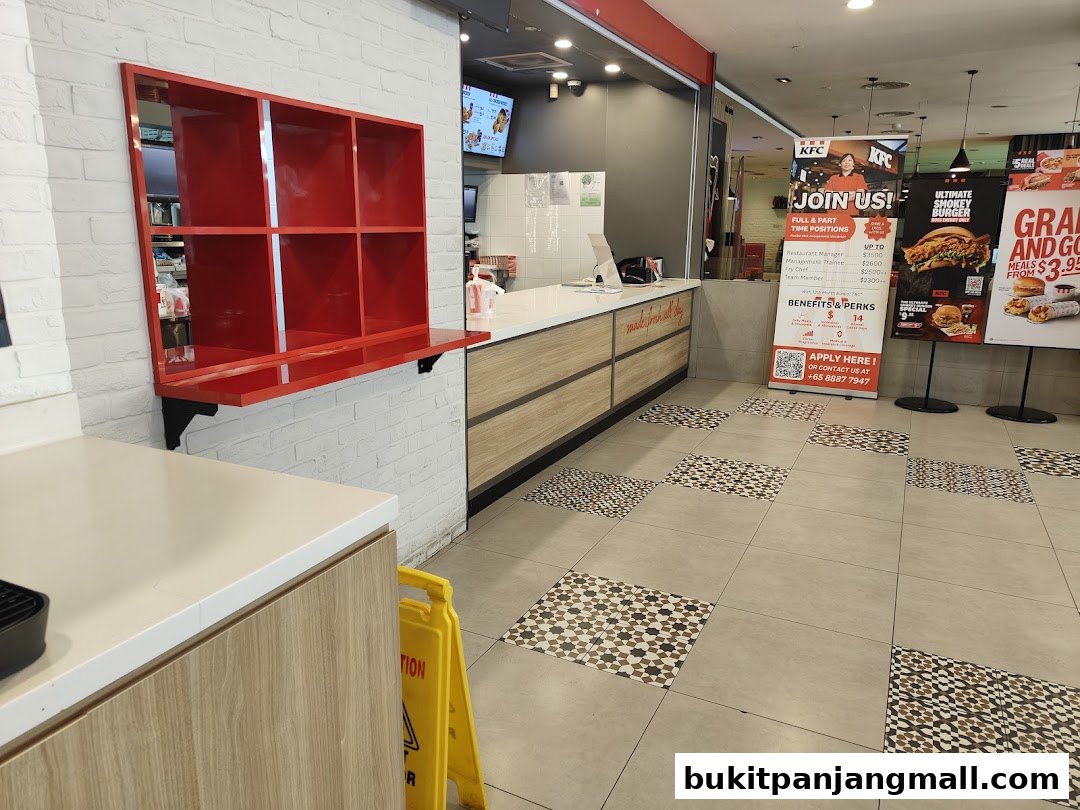 Interior view of a KFC restaurant with a counter, promotional posters, and seating area.