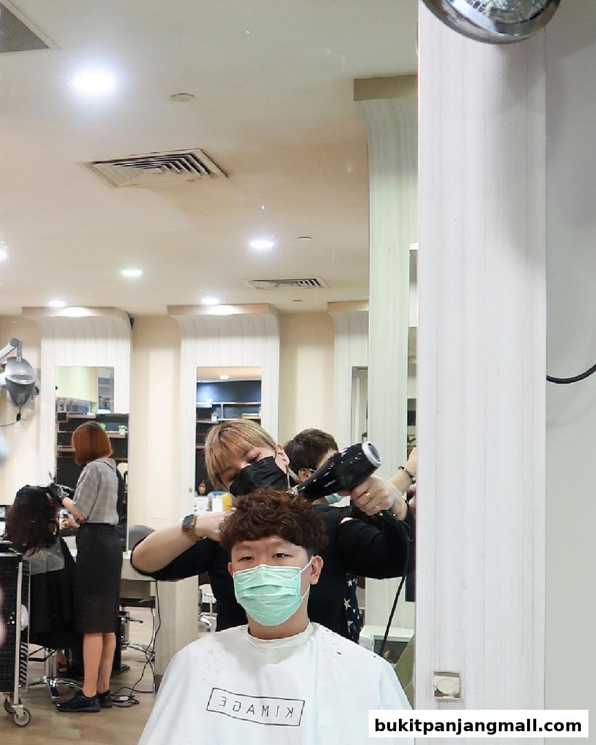 A hairstylist drying a customer's hair at Kimage Hair Salon.