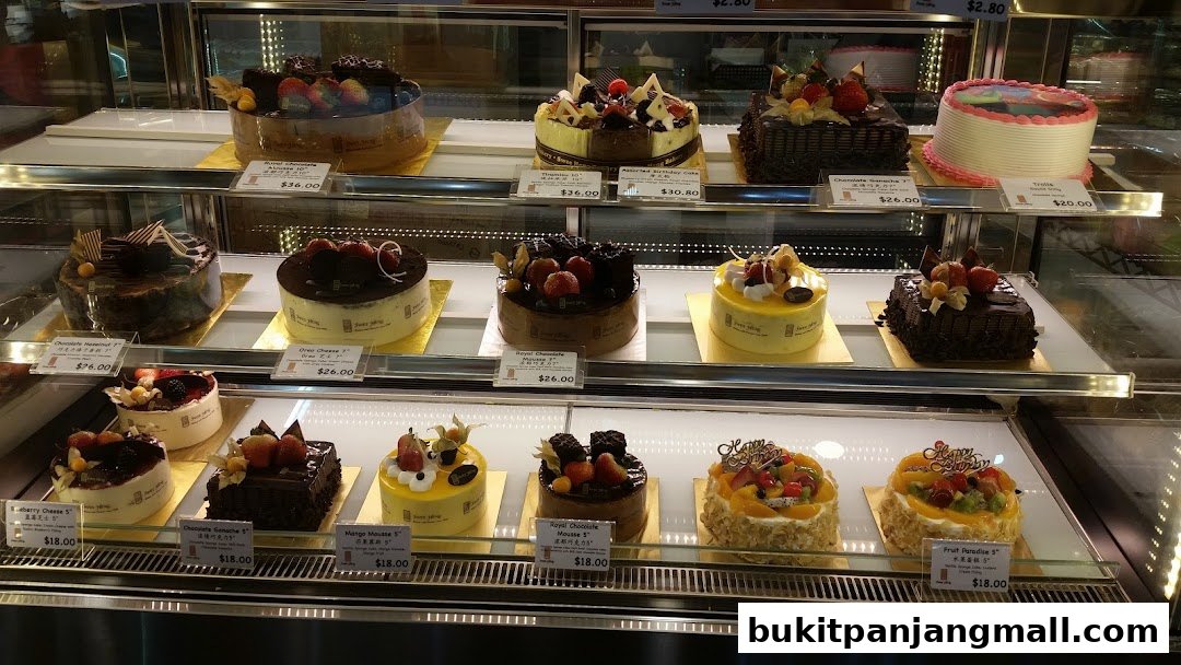 A display case filled with a variety of beautifully decorated cakes and pastries.