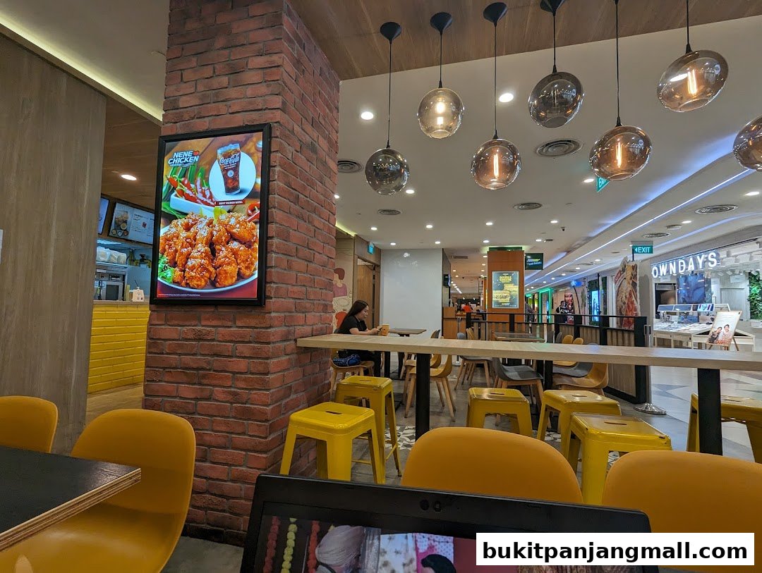Interior view of NeNe Chicken restaurant with a display of fried chicken and seating.