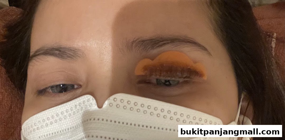 Close-up of a person's eye undergoing a lash lift treatment with a perm rod.