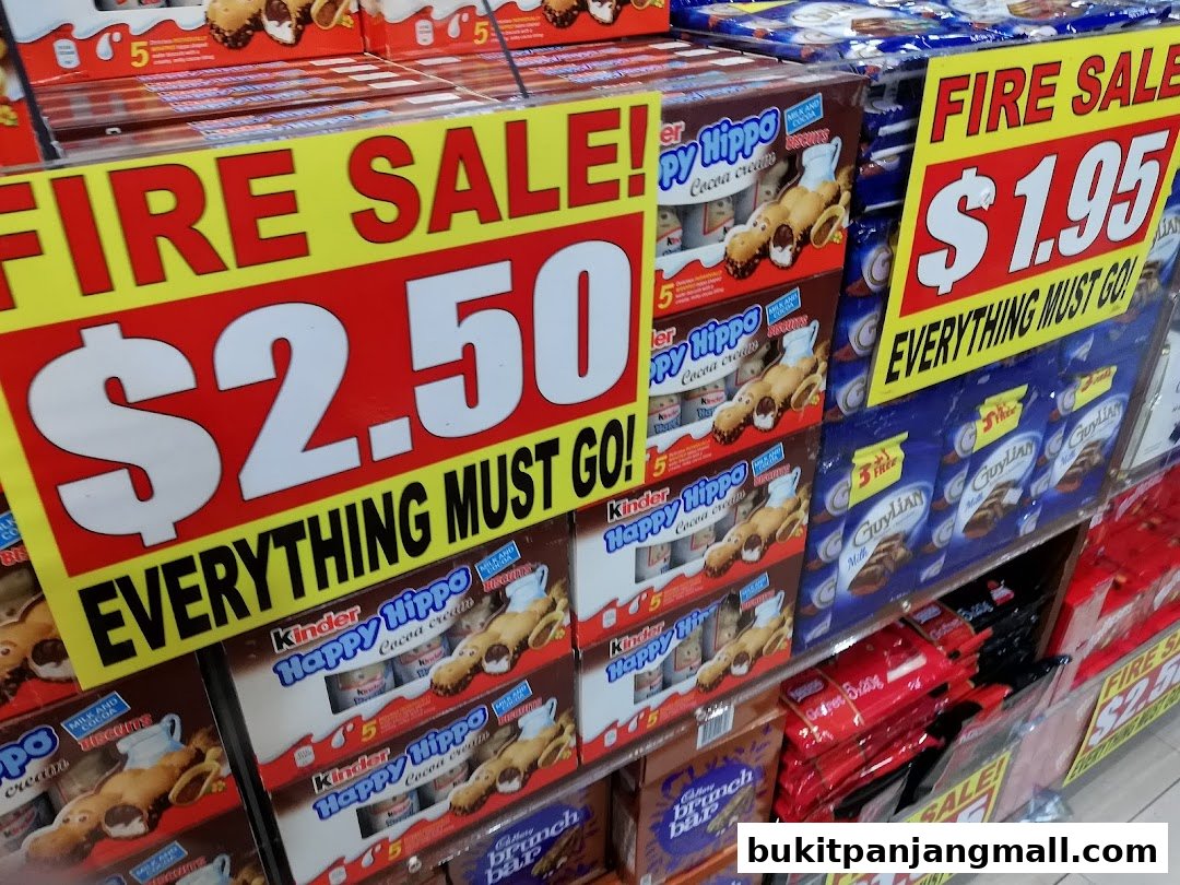 A display of various snack boxes and chocolate bars with prominent 'Fire Sale' signs.