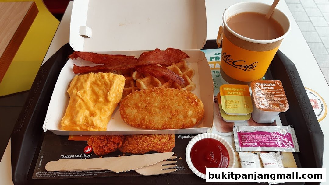 A McDonald's breakfast tray with scrambled eggs, bacon, waffles, hash brown, and McCafe coffee.