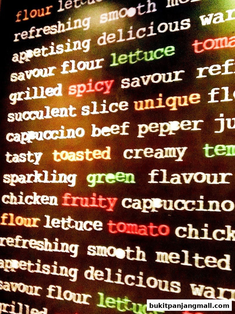 A close-up of text on a dark background, featuring various food-related words in different colors.