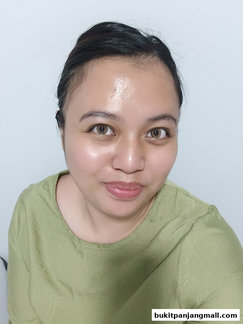 A woman with glowing skin and light makeup smiles gently.
