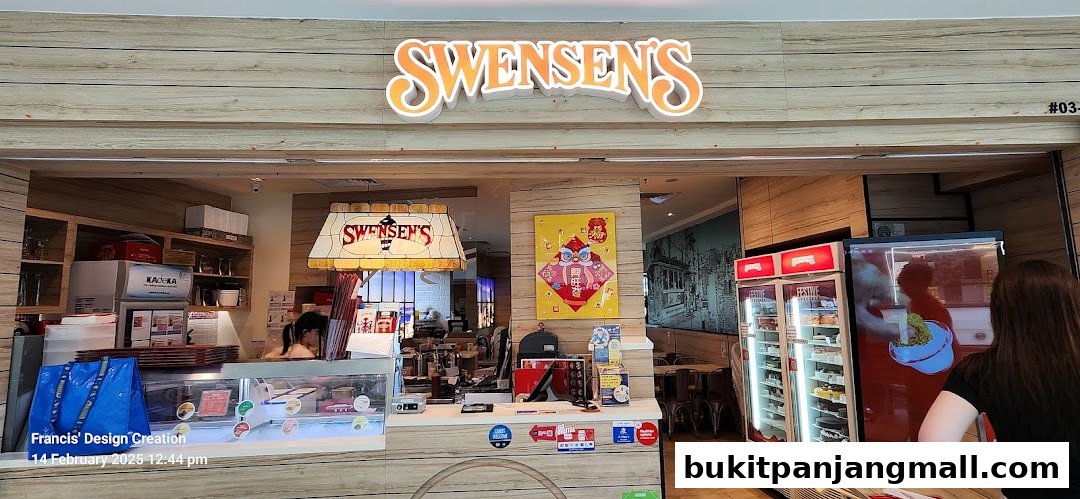 The entrance of Swensen's ice cream and dessert shop with a display of cakes and a counter.